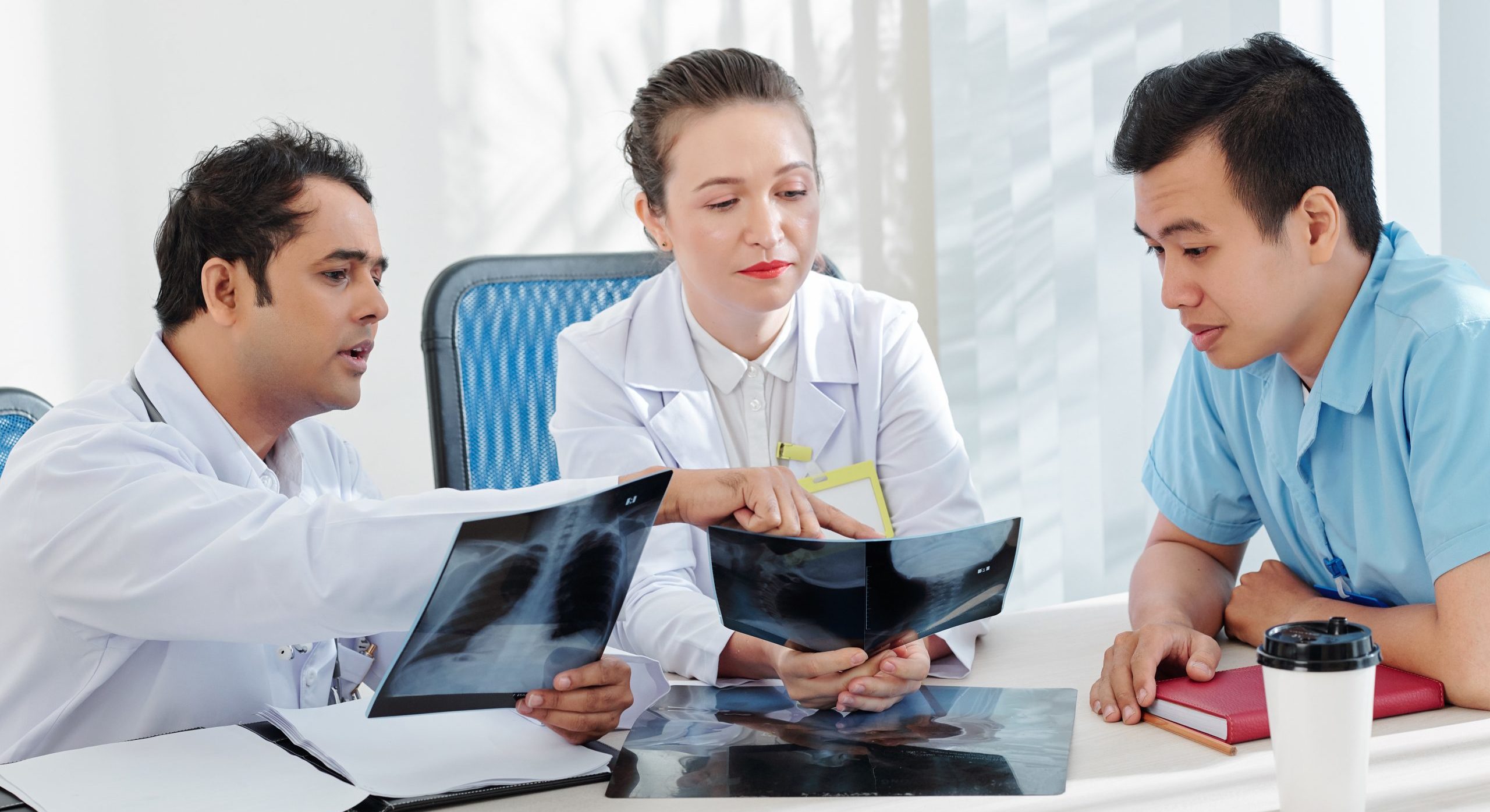 Group,Of,Serious,Medical,Workers,Discussing,Chest,X-rays,Of,Patient